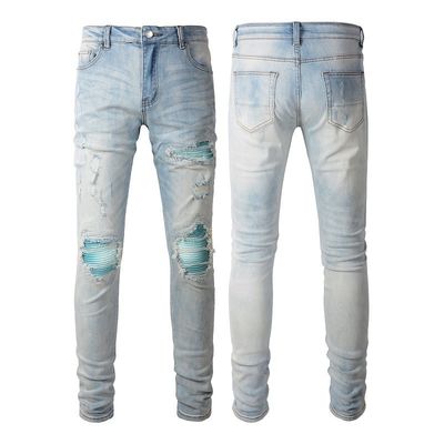 Le style punk est le style masculin déchiré mince taille moyenne bleu denim vintage étirement lavé