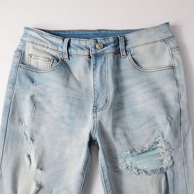 Le style punk est le style masculin déchiré mince taille moyenne bleu denim vintage étirement lavé